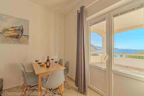 a dining room with a table and chairs and a window at Sladana direct at the beach in Metajna
