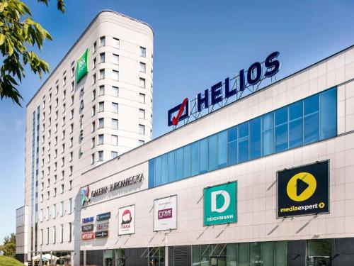 a heitzos building with a sign on top of it at ibis Styles Bialystok in Białystok