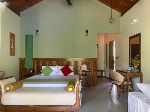 a bedroom with a bed and a table and chairs at River Shades Hotel in Hikkaduwa