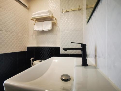 a bathroom with a sink and a faucet at Pattaya Pool View Condo in Nong Prue