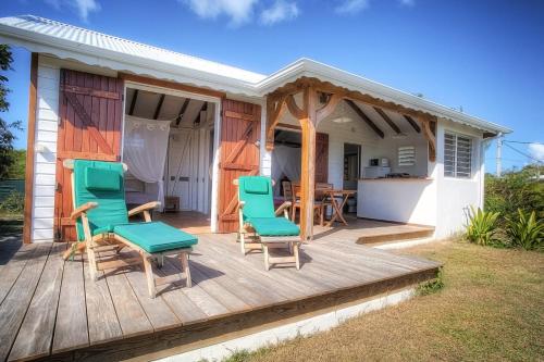 a deck with chairs and a table on a house at Gîte Pointe des Châteaux in Saint-François
