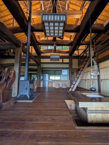 a large room with wooden floors and a wooden ceiling at Yamanoto in Toyooka