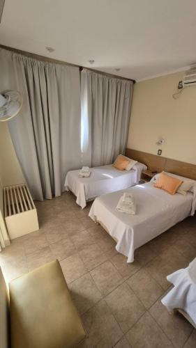 two beds in a hotel room with curtains at Hotel La Giralda CAZ in Vera
