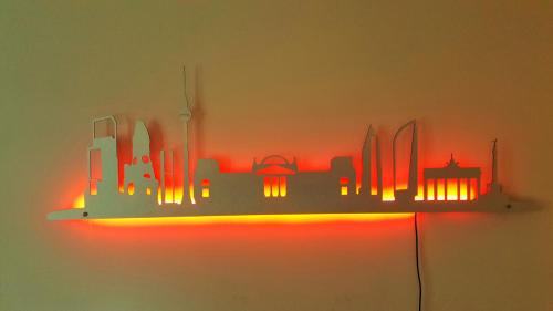 a shelf with a lit up city on the wall at Ferienhaus Sanssouci in Stahnsdorf