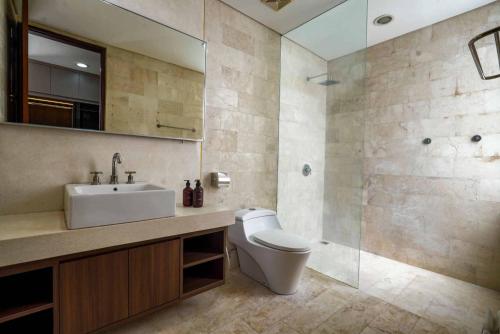 a bathroom with a toilet and a sink and a shower at Norm Villa Kuta in Kuta