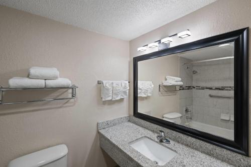 a bathroom with a sink and a mirror at Super 8 by Wyndham Lake City in Lake City