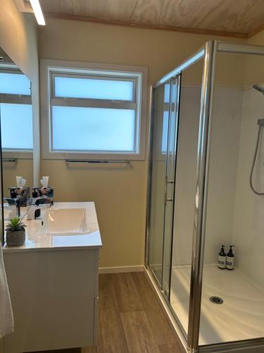 a bathroom with a sink and a shower at A Gem by the Beach 4 bedroom Abel Tasman in Kaiteriteri