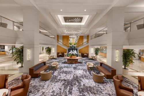 a lobby of a hotel with chairs and a waiting room at Hilton Los Angeles Airport in Los Angeles