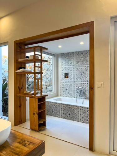 a bathroom with a tub and a large window at Vanthra Vilas, Jawai - Luxury Villas with Private Pools in Bijāpur