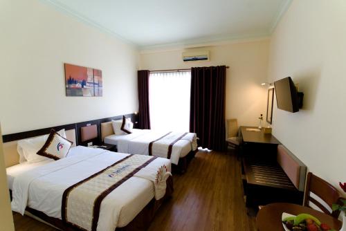 a hotel room with two beds and a window at Park View Hotel in Hue