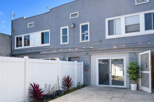 a house with a white fence in front of it at Vernon Homes For The Soul in Los Angeles