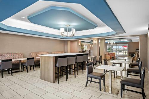 a restaurant with a blue ceiling and tables and chairs at La Quinta by Wyndham Searcy in Searcy