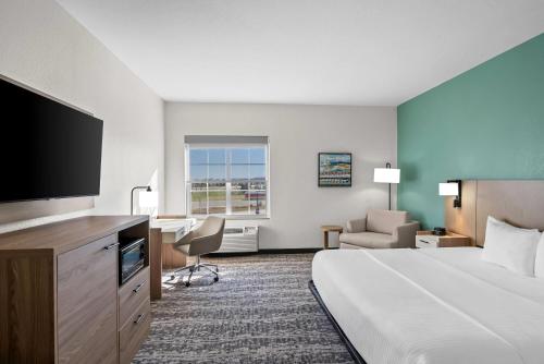 a hotel room with a bed and a flat screen tv at La Quinta by Wyndham Searcy in Searcy