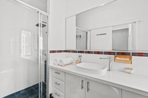 a white bathroom with a sink and a shower at Equitice Autumn Moonlight Villa in Perth