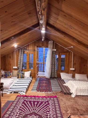 a room with two beds in a room with wooden ceilings at The Quiet Corner in Gushaini