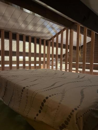 a wooden bunk bed with a white blanket on it at Le Chalet in Les Costes-Gozon