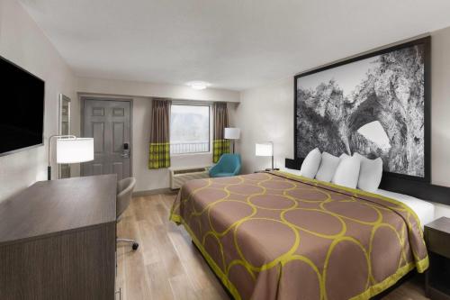 a hotel room with a bed and a flat screen tv at Super 8 by Wyndham Charleston WV in Charleston