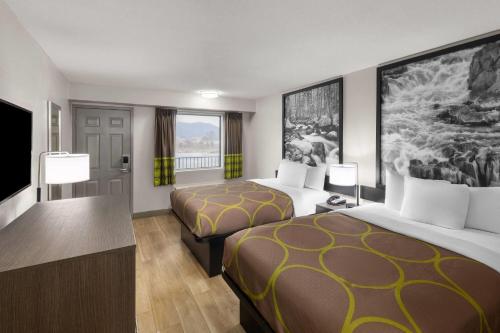 a hotel room with two beds and a television at Super 8 by Wyndham Charleston WV in Charleston