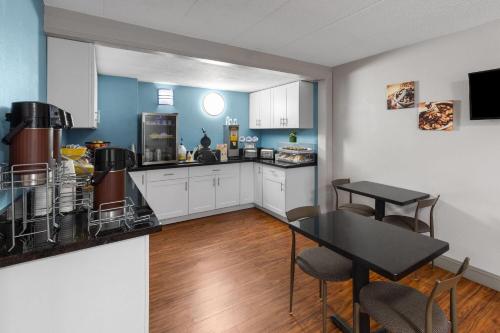 a kitchen with white cabinets and a table and chairs at Super 8 by Wyndham Charleston WV in Charleston