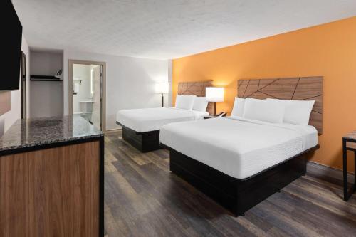 a hotel room with two beds and a television at Howard Johnson by Wyndham Malden Boston Area in Malden