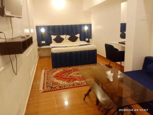 a living room with a bed and a table and a room at Prince Lodge and Banquet in Khairāni
