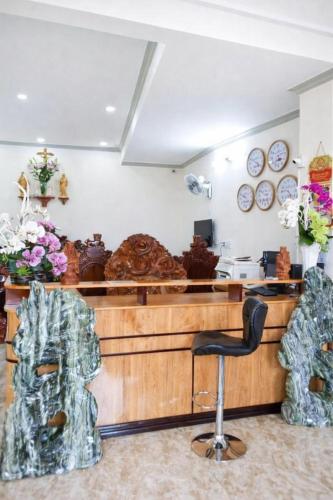 a salon with a counter with a chair and flowers at Kim Ngân Hotel Buôn Ma Thuột in Buon Ma Thuot