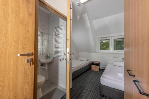 a small bathroom with two beds and a sink at Ośrodek Wypoczynkowy Caritas in Wałcz