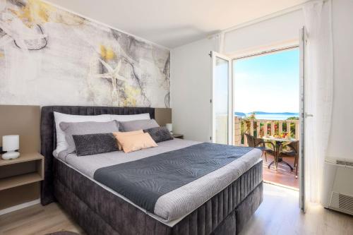 a bedroom with a large bed and a balcony at Villa Panorama Dubrovnik in Mlini
