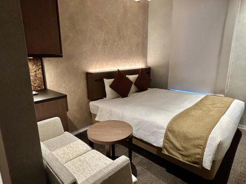 a small hotel room with a bed and a table at Ginza International Hotel in Tokyo