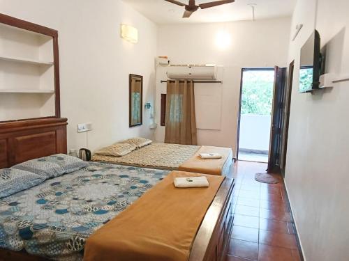 a bedroom with two beds and a ceiling fan at La Ruelle Guest House in Pondicherry