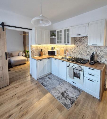 a kitchen with white cabinets and a stove top oven at Apartmán Sárka Brezno in Brezno