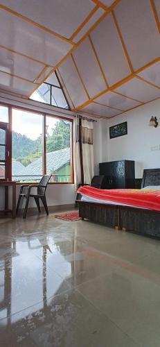 a bedroom with a bed and a table and a window at DreamCatcher & Homestay in McLeod Ganj