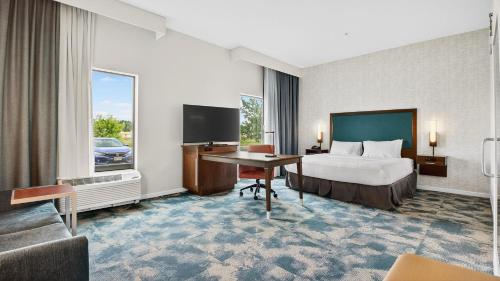 a hotel room with a bed and a desk at Hampton Inn & Suites Chippewa Falls in Chippewa Falls