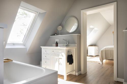 a bathroom with a sink and a bath tub at Fischerkate - Ostholstein in Stocksee