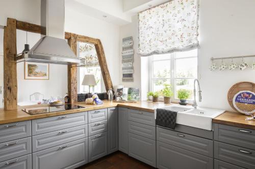 a kitchen with white cabinets and a sink and a window at Pächterhaus - Ostholstein in Manhagen