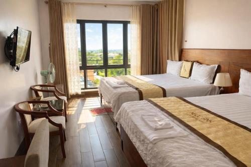 a hotel room with two beds and a window at Hotel Ngoc Anh - Van Don in Quang Ninh