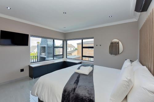 a bedroom with a large bed and a large window at Grey Luxury Accommodation Langebaan in Langebaan
