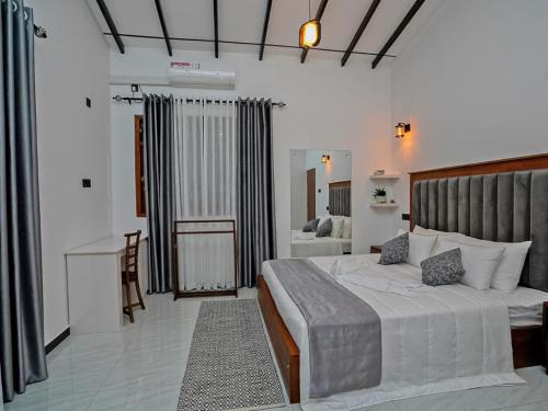 a bedroom with a large white bed and a desk at Ceylon Vista in Galle
