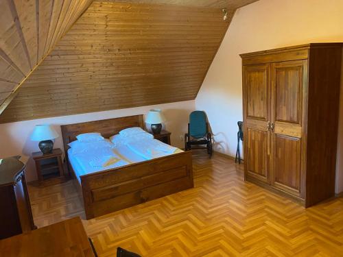 a bedroom with a large bed and a wooden wall at Juhász Fogadó in Fonyód