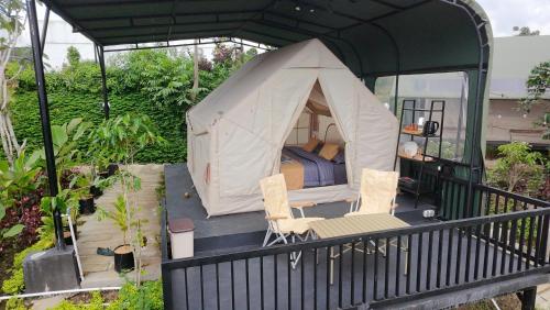 a tent with two chairs and a bed in it at Arjuno Chatten Valley in Punten
