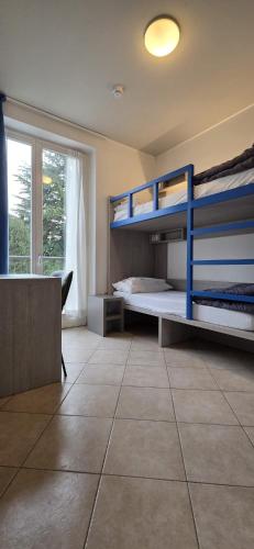 a bedroom with two bunk beds and a window at Ostello Città di Rovereto in Rovereto