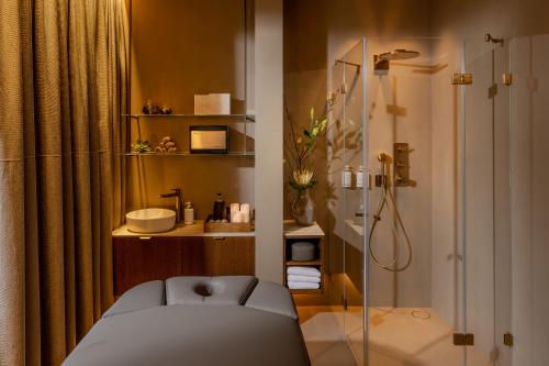 a bathroom with a shower and a glass shower stall at Grand Hotel Zermatterhof in Zermatt
