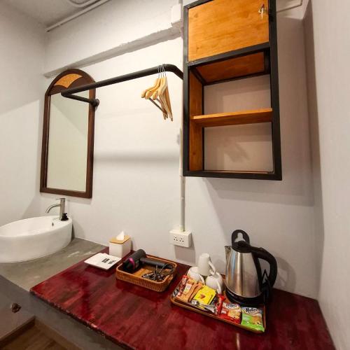 a bathroom counter with a sink and a mirror at Hometown Stays Hatyai in Hat Yai