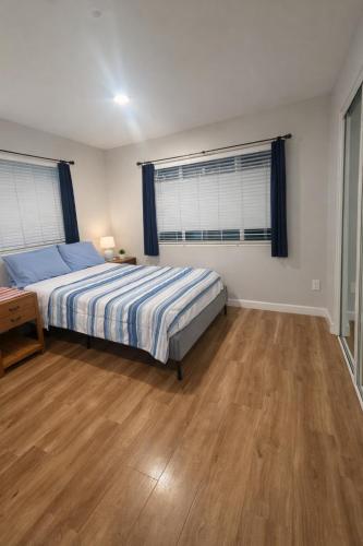 a bedroom with a bed and a wooden floor at Santa Ana Love Home in Santa Ana