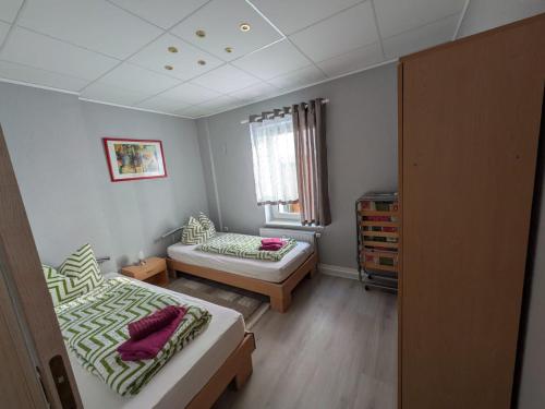 a small room with two beds and a window at Pension Remenar & Lorenz in Zeithain