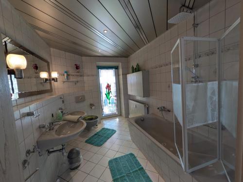 a bathroom with a tub and a sink and a shower at Pension Remenar & Lorenz in Zeithain