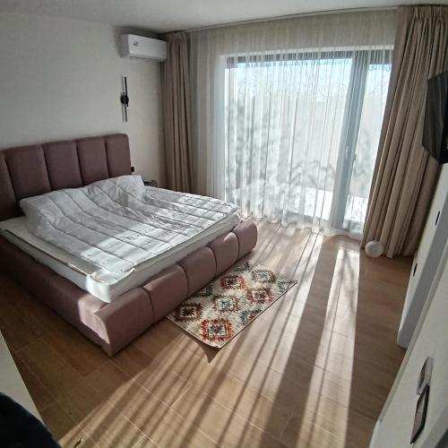 ein Schlafzimmer mit einem Bett und einem großen Fenster in der Unterkunft Avabi Concept in Nenciu