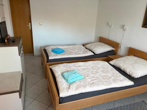 two twin beds in a room with a kitchen at Zimmervermietung Lippmann in Großhartmannsdorf