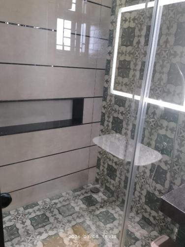 a bathroom with a shower with a glass door at Sharvin Villa in Karaikal