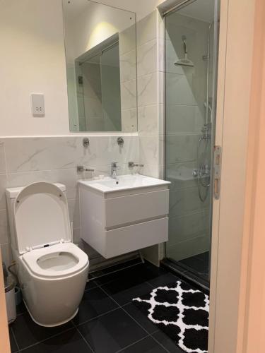 a bathroom with a toilet and a sink and a shower at One Bedroom Premium Luxury Apartments at The Embassy Garderns in Cantonments